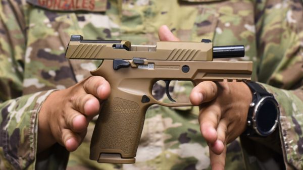 Staff Sgt. Will Gonzales, 36th Security Forces Squadron armory NCO in charge, displays a Sig Sauer M18 pistol on Andersen Air Force Base, Guam, Aug. 26, 2019. The M18 provides improved trigger pull, tritium night sights, larger ammo capacity, weapon reliability and durability to strengthen shooter lethality. (U.S. Air Force photo by Airman 1st Class Michael S. Murphy)