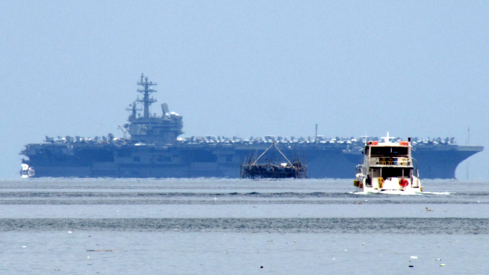 The USS Ronald Reagan (CVN-76), a Nimitz-class Aircraft Carrier of the United States Navy (USN) as seen from the SM by the Bay Amusement Park.