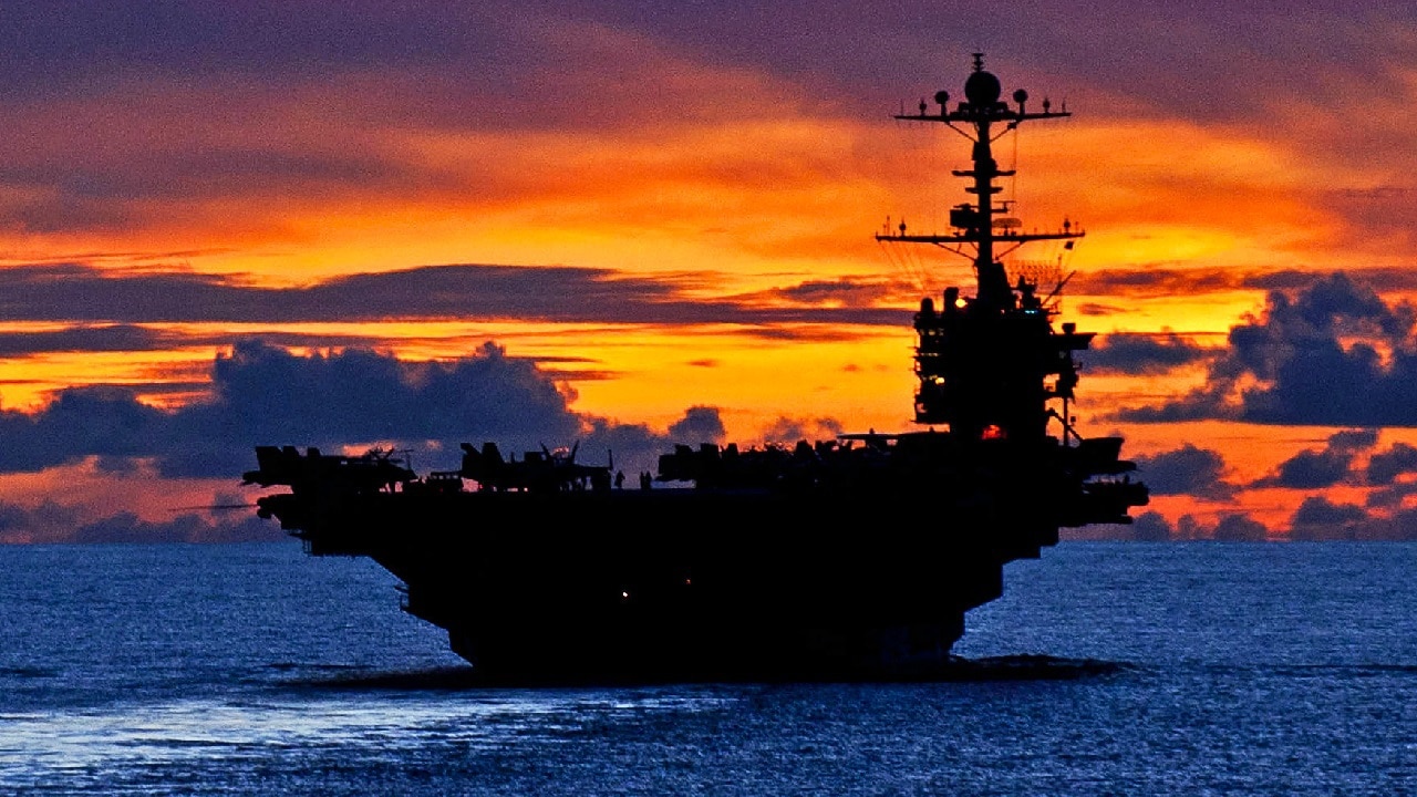The aircraft carrier USS George Washington sails through calm seas near Guam at sunset while under way in the Pacific Ocean, Sept. 8, 2012. The George Washington is the centerpiece of Carrier Strike Group 5, the US Navy’s only continuously forward deployed carrier strike group, based out of Yokosuka, Japan. Carrier Strike Group 5 is currently on a routine Western Pacific patrol. Image Credit: Creative Commons.