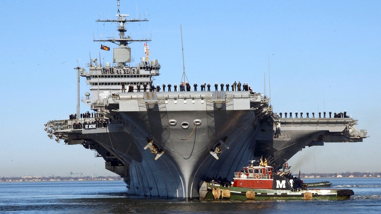 Naval Station Norfolk, Va. (Feb. 29, 2004) – Sailors aboard the nuclear powered aircraft carrier USS Enterprise (CVN 65) "man the rails" as the carrier approaches its pier at her homeport of Naval Station Norfolk, Va. The carrier and its strike group are returning after completing a six-month deployment in support of the global war of terrorism, including Operations Iraqi Freedom and Enduring Freedom. U.S. Navy photo by Photographer’s Mate 3rd Class Sondra Howett. (RELEASED)