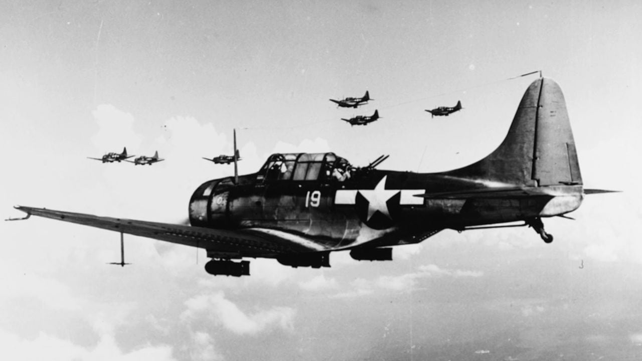 U.S. Navy Douglas SBD-5 Dauntless dive bombers of Bombing Squadron 16 (VB-16), Carrier Air Group 16, from the aircraft carrier USS Lexington (CV-16), fly over the invasion fleet off Saipan, on "D-Day", 15 June 1944. Image Credit: Creative Commons.