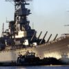 A tug boat nudges the bow of the battleship USS Wisconsin (BB 64) as the ship is pushed from the Norfolk Naval Shipyard to the Nauticus Museum in Norfolk, Va., on Dec. 7, 2000. The Wisconsin will be the centerpiece of a four-part exhibit on the battleship's role in Naval history.