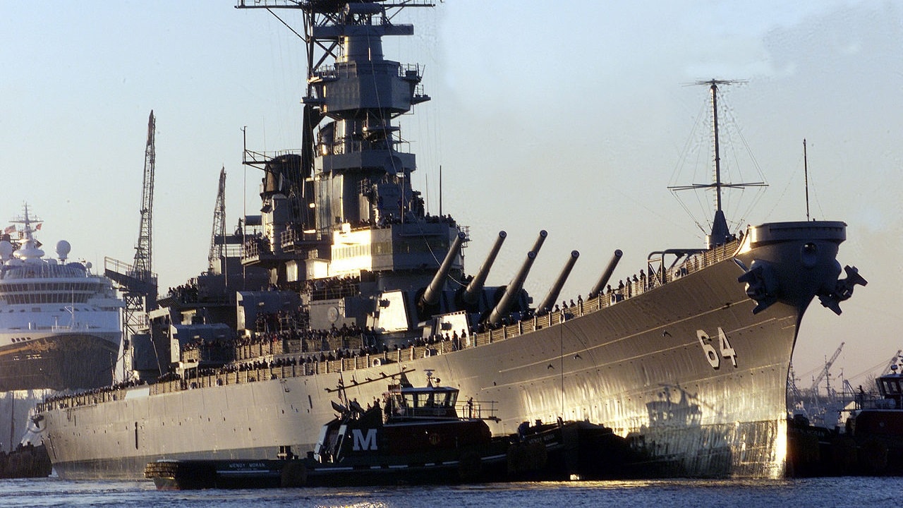 A tug boat nudges the bow of the battleship USS Wisconsin (BB 64) as the ship is pushed from the Norfolk Naval Shipyard to the Nauticus Museum in Norfolk, Va., on Dec. 7, 2000. The Wisconsin will be the centerpiece of a four-part exhibit on the battleship's role in Naval history.