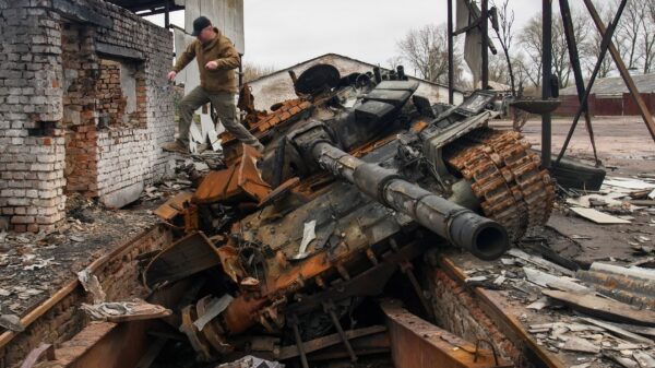 A man jumps from a Russian T-72 tank destroyed during Russia's invasion, in the village of Yahidne, Ukraine April 20, 2022. REUTERS/Vladyslav Musiienko