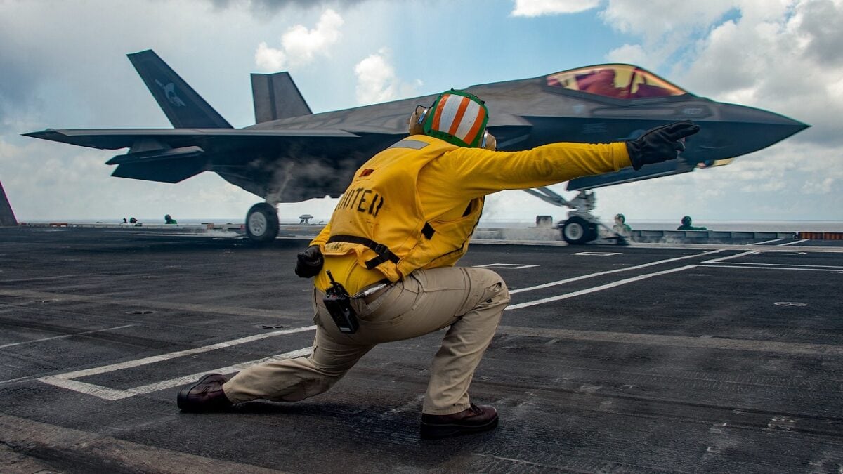 SOUTH CHINA SEA (Oct. 25, 2021) Lt. Nicholas Eppler, from Exeter, Calif., directs flight operations as an F-35C Lightning II assigned to the “Argonauts” of Strike Fighter Squadron (VFA) 147 launches from the Nimitz-class aircraft carrier USS Carl Vinson (CVN 70), Oct. 25, 2021. The Carl Vinson Carrier Strike Group is on a scheduled deployment in the U.S. 7th Fleet area of operations to enhance interoperability through alliances and partnerships while serving as a ready-response force in support of a free and open Indo-Pacific region. (U.S. Navy photo by Mass Communication Specialist Seaman Emily Claire Bennett) 211025-N-TY704-1241