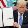 President Donald J. Trump displays his signature after signing an Executive Order on Protecting American Monuments, Memorials, and Statues and Combating Recent Criminal Violence, Friday, June 26, 2020, in the Oval Office of the White House. (Official White House Photo by Tia Dufour)