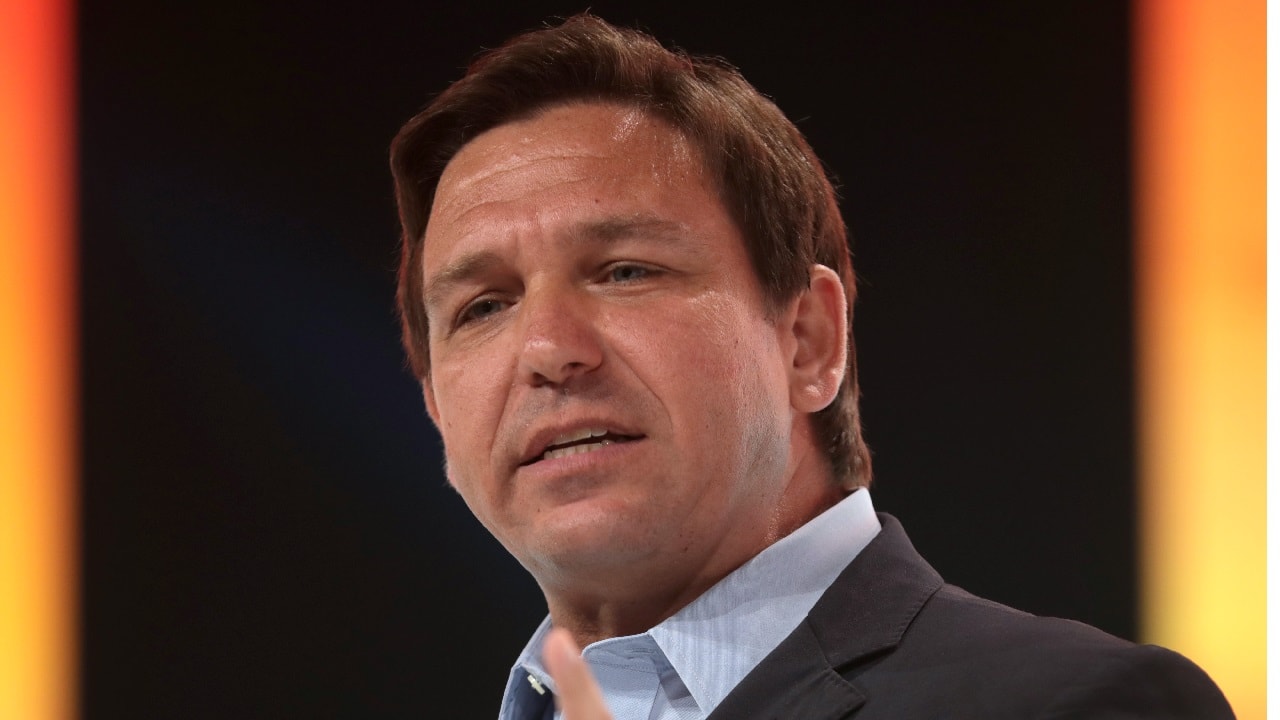 By Gage Skidmore: Governor Ron DeSantis speaking with attendees at the 2021 Student Action Summit hosted by Turning Point USA at the Tampa Convention Center in Tampa, Florida.