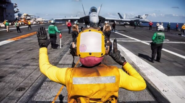 A U.S. Sailor signals to an F/A-18F Super Hornet aircraft, attached to Strike Fighter Squadron 213, on the flight deck of the world's largest aircraft carrier, Ford-class aircraft carrier USS Gerald R. Ford (CVN 78), while underway in the Caribbean Sea, Feb. 5, 2026. U.S. military forces are deployed to the Caribbean in support of the U.S. Southern Command mission, Department of War-directed operations, and the president’s priorities to disrupt illicit drug trafficking and protect the homeland. (U.S. Navy photo)