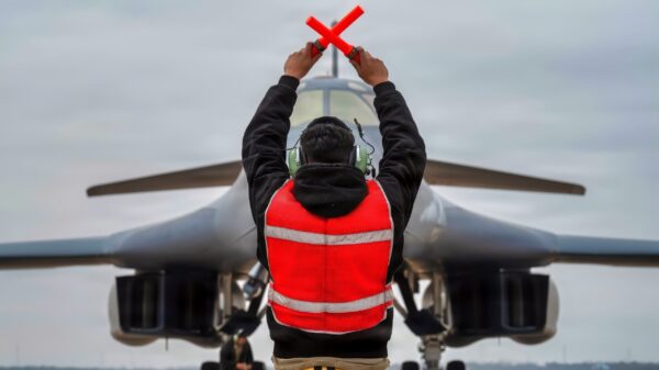 A U.S. Air Force B-1B Lancer crew chief marshals a B-1 after returning from a CONUS-to-CONUS mission in support of Operation Epic Fury, March 4, 2026. The B-1B is a long-range, multi-role bomber that carries the largest payload of precision guided and unguided munitions in the Air Force inventory. (U.S. Air Force photo)