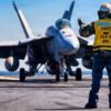 A U.S. Sailor signals to an F/A-18E Super Hornet aircraft, attached to Strike Fighter Squadron 31, on the flight deck of the world's largest aircraft carrier, USS Gerald R. Ford (CVN 78), while underway during Operation Epic Fury, March 9, 2026. (U.S. Navy photo)