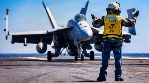 A U.S. Sailor signals to an F/A-18E Super Hornet aircraft, attached to Strike Fighter Squadron 31, on the flight deck of the world's largest aircraft carrier, USS Gerald R. Ford (CVN 78), while underway during Operation Epic Fury, March 9, 2026. (U.S. Navy photo)