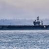 The Nimitz class aircraft carrier USS Nimitz (CVN 68) passes by a Washington State Ferry as it transits Puget Sound during the ship’s final departure from Naval Base Kitsap-Bremerton, Washington, March 7, 2026. Nimitz is underway in the U.S. 3rd Fleet area of operations as part of a scheduled homeport shift to Norfolk, Virginia. (U.S. Navy photo by Mass Communication Specialist Seaman Kimberli Ibarra Ruiz)