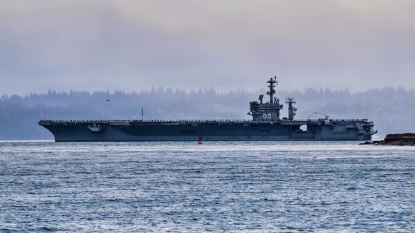The Nimitz class aircraft carrier USS Nimitz (CVN 68) passes by a Washington State Ferry as it transits Puget Sound during the ship’s final departure from Naval Base Kitsap-Bremerton, Washington, March 7, 2026. Nimitz is underway in the U.S. 3rd Fleet area of operations as part of a scheduled homeport shift to Norfolk, Virginia. (U.S. Navy photo by Mass Communication Specialist Seaman Kimberli Ibarra Ruiz)