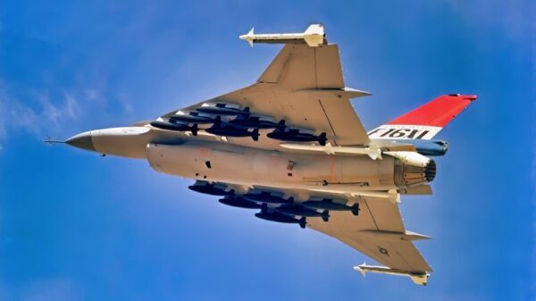 An air to air left underside view of an F-16XL aircraft. The aircraft is armed with two wing tip mounted AIM-9 Sidewinder and four fuselage mounted AIM-7 Sparrow missiles along with 12 500-pound bombs.