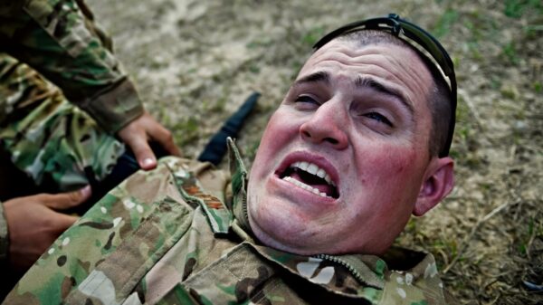 U.S. Air Force Staff Sgt. Sean Martin, 1st Combat Camera Squadron combat photojournalist, simulates crying out in pain for tourniquet training during Scorpion Lens 2016 at Fort Jackson S.C., March 5, 2016. Exercise Scorpion Lens 2016 is an annual Ability To Survive and Operate training evolution mandated by Air Force 3N0XX Job Qualification Standards (3N0XX AFJQS). Individuals are instructed using a crawl, walk, run format of training. The exercise is twofold containing the Scorpion Lens portion, dedicated to Advanced Weapons and Tactical Training (AWTT) and the Flash Bang portion dedicated to providing photography and videography documentation standards in combat situations. The purpose of the training is to provide refresher training to combat camera personnel of all ranks and skill levels in basic tactics, techniques, and procedures inherent to combat camera mission tasking. (U.S. Air Force photo by Airman 1st Class Kyle Hagan)