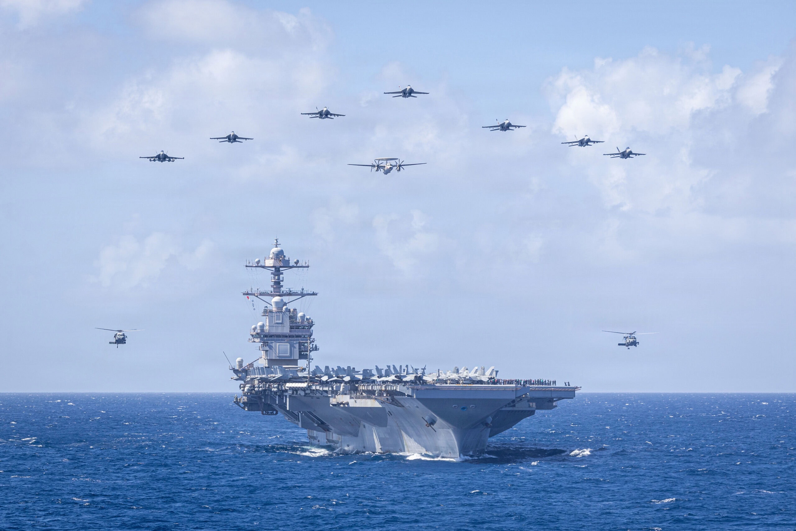 U.S. Navy Carrier Air Wing 8 aircraft fly in formation over the world’s largest aircraft carrier, Ford-class aircraft carrier USS Gerald R. Ford (CVN 78), during Carrier Air Wing 8’s aerial change of command ceremony while underway in the Caribbean Sea, Jan. 19, 2026. U.S. military forces are deployed to the Caribbean in support of the U.S. Southern Command mission, Department of War-directed operations, and the president’s priorities to disrupt illicit drug trafficking and protect the homeland. (U.S. Navy photo)