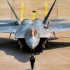 U.S. Air Force Staff Sgt. Robin Wharton, multi-capable Airman, left, and Tech. Sgt. Jarred Cool, a dedicated crew chief, both assigned to the F-22 Raptor Demonstration Team, perform the team's silent ground show prior to an aerial demonstration at the Cold Lake Airshow in Cold Lake, Alberta, Canada, July 18, 2026. The airshow brought U.S. and Canadian performers and communities together, highlighting the strong partnership between two nations united by a shared passion for aviation. This demonstration highlights the unique thrust-vectoring capabilities of the F-22, allowing it to achieve extreme agility unmatched by other fighter aircraft. (U.S. Air Force photo by Staff Sgt. Lauren Diaz)