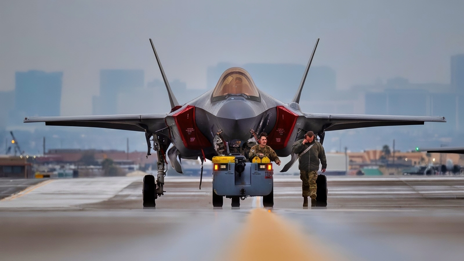 U.S Air Force Senior Airman Kyle Lemanski, left, and Senior Airman Paul Sullivan, crew chiefs assigned to the 421st Fighter Generation Squadron, Hill Air Force Base (AFB), Utah, tow an F-35 Lightning II down the flight line while another F-35 Lightning II taxis during Red Flag-Nellis 24-1 at Nellis AFB, Jan. 22, 2024. This Red Flag will have approximately 30 units and close to 2,000 participants from U.S. and Allied forces. (U.S. Air Force photo by Senior Airman Zachary Rufus)